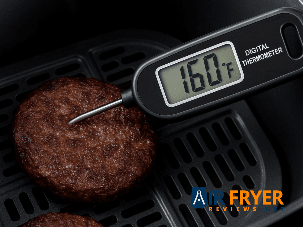 Digital meat thermometer 160°F inserted into the center of a cooked frozen burger patty.