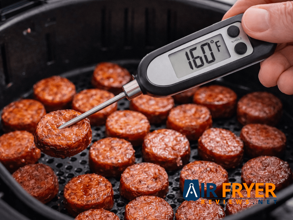 An instant read thermometer inserted into a kielbasa slice displaying 160°F Air Fryer Reviews